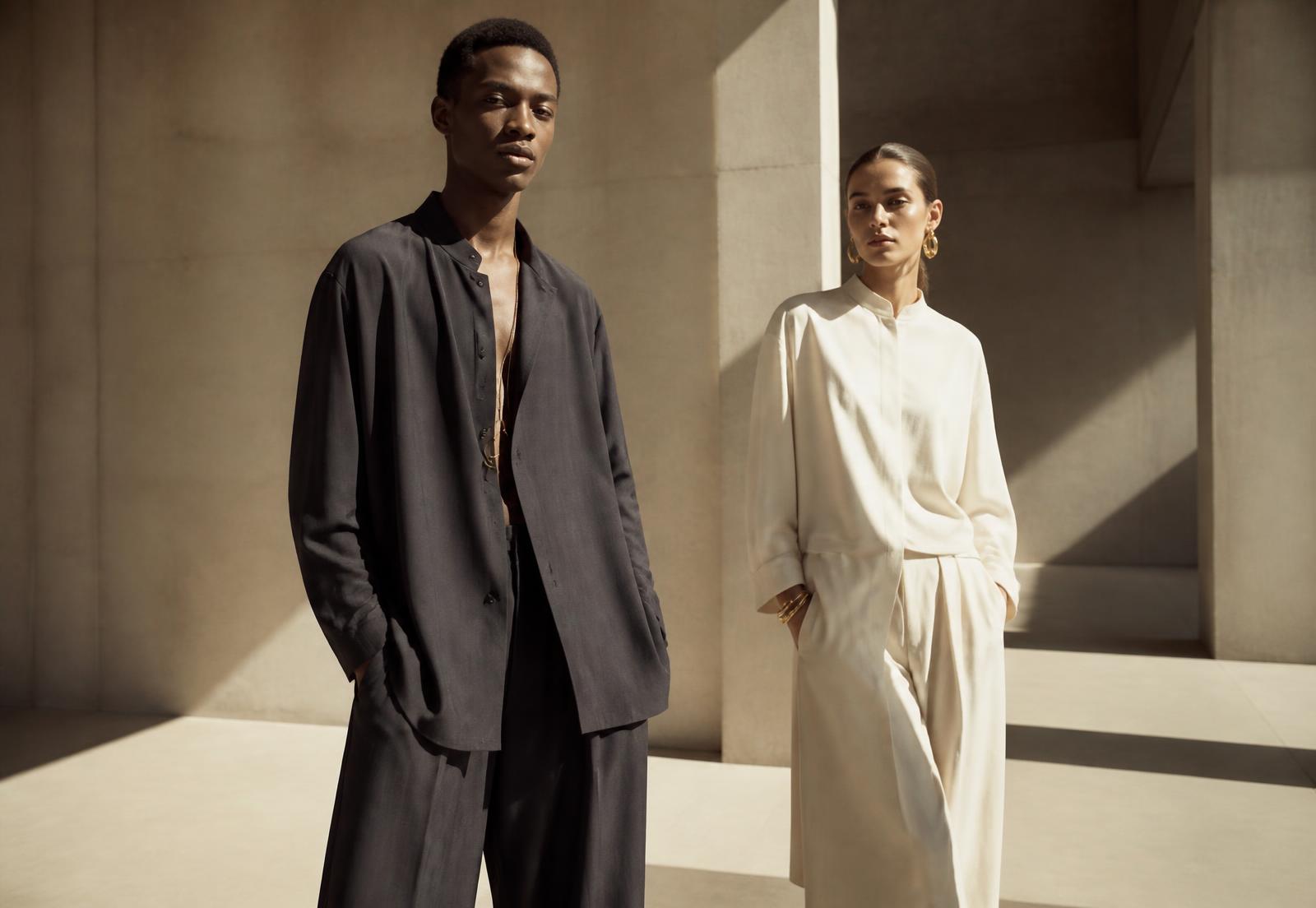 Two models wearing Callon Avery tailoring in a sunlit gallery space